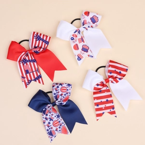 Detail of four Independence Day bow hair ties with patriotic stars and stripes patterns
