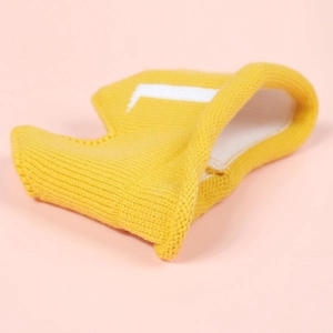 Detail view of yellow knit crown hat with white letter pattern for baby birthday