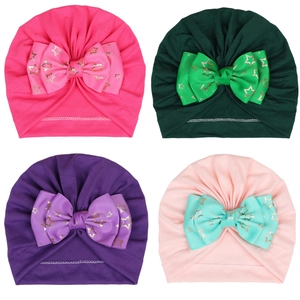 Detail of baby turban hats with large bows and gold star prints in four vibrant colors
