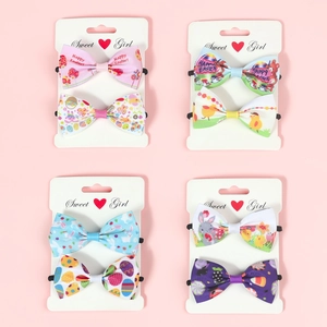 Close-up of Easter bow hair ties featuring rabbit and egg patterns on display cards