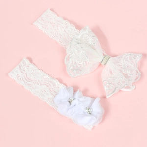 Détail de l'ensemble bandeau bébé en dentelle blanche avec strass et fleurs en mousseline