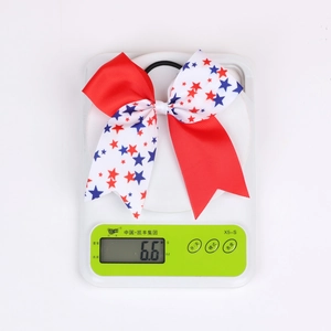 Detail view of Independence Day themed hair bow weighing 6.6g on a digital scale