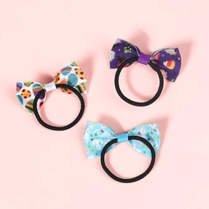 Detailed view of three Easter bow hair ties with purple dots, bunnies, and colorful eggs