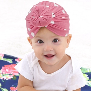 Détail du bonnet à nœud rose à pois pour bébé en coton extensible et doux