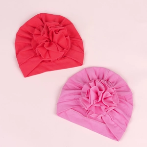 Solid color baby turban hat with large layered flower for newborns aged zero to six months