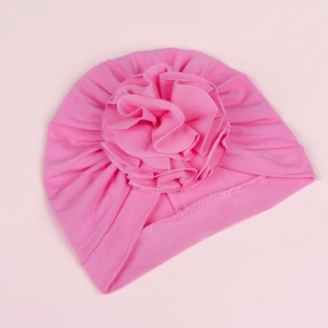 Detailed view of pink baby turban hat featuring a large 3D fabric flower and ribbed texture