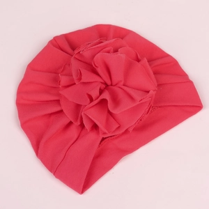 Detail of soft ribbed watermelon red cotton turban hat for babies with large floral design