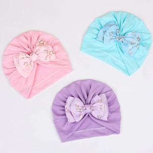 Close-up of baby turban hats with large bows and gold star patterns in three soft colors