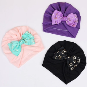 Three-piece baby turban hat set with large gold star print bows in purple, pink, and black