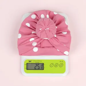 Vue détaillée du turban léger en coton rose pour bébé pesant 25,1 g sur une balance