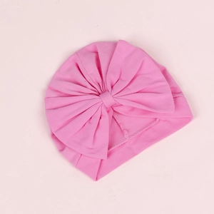 Détail du bonnet turban rose pour bébé avec un grand nœud et une texture en coton côtelé