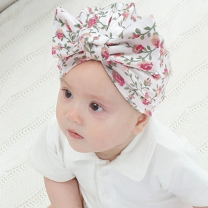 Détail du turban pour bébé à motif floral avec un grand nœud en maille douce