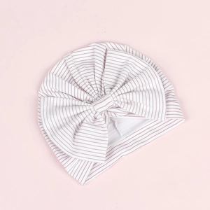 Détail du turban pour bébé avec rayures violettes et un grand nœud décoratif doux