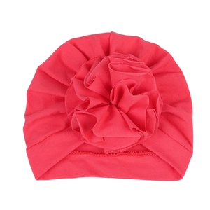 Coral red newborn turban hat with a large decorative fabric flower for 0-6 months baby