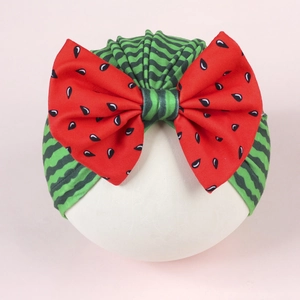 Infant watermelon turban hat featuring green wavy stripes and a large red seed bow