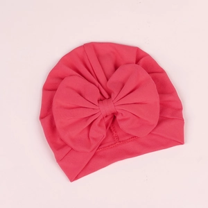 Détail du tissu en coton doux et du grand nœud sur un turban rose pour nourrisson