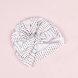 Détail du bonnet turban rayé pour bébé en coton doux avec un grand nœud décoratif