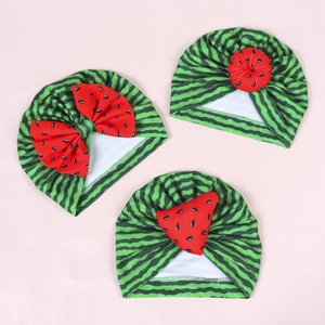 Detail of baby hats with watermelon stripes and red bow or pompom decorations