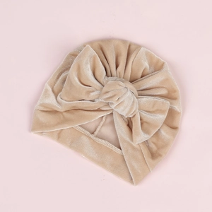 Détail du bonnet turban bébé en velours avec grand nœud de couleur abricot