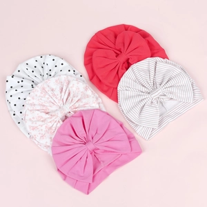 Détail d'un lot de cinq turbans en coton pour bébé avec pois et motifs floraux doux