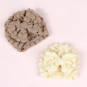 Close-up of baby turban hats with large bows in brown and cream textured seersucker fabric