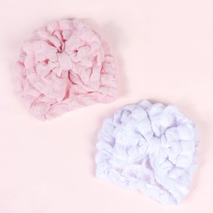Detailed texture of baby turban hat featuring a large bow and soft seersucker fabric