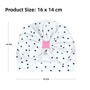 Détail du bonnet turban pour bébé en coton à pois avec un grand nœud rose décoratif