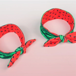 Detailed view of elastic watermelon bow headbands with red pulp and green rind textures