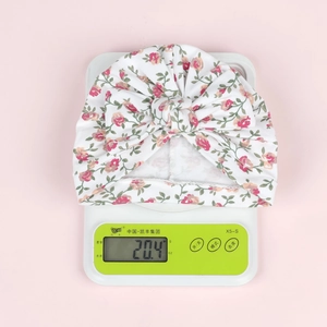 Détail du turban léger de 20,4g pour bébé avec motif floral et grand nœud frontal