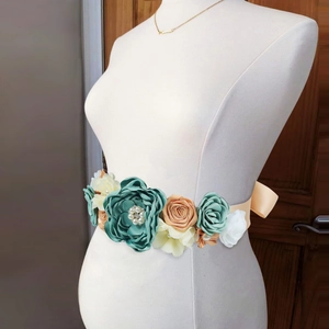 Detail of sage green floral sash with pearls and silk ribbon for maternity photoshoot