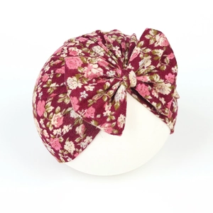 Detailed view of dark red floral baby turban hat with a large bow and soft knit fabric