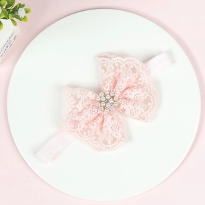 Vue détaillée d'un bandeau en dentelle rose avec ornement central en perles et strass