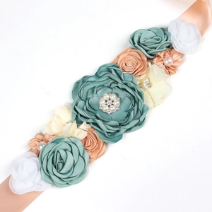 Champagne maternity sash with green and pink handmade flowers, pearls, and rhinestones