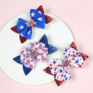 Close-up of glitter bow hair clips featuring American Independence Day patterns on white plate