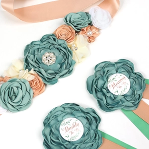 Detail of Mom to Be sash and corsage set with green flowers and pearl accents