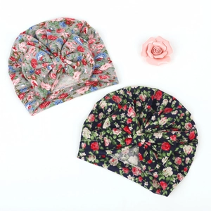 Detailed top view of two baby turban hats with floral patterns and large bows