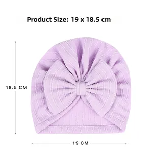 Detail of lavender baby turban hat with large bow showing ribbed fabric texture and size