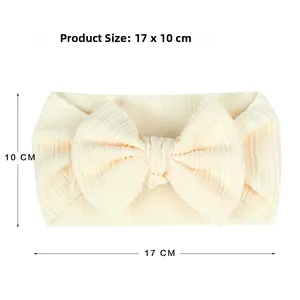 Detail showing solid cream bow headband for babies with 17x10cm product size dimensions