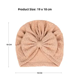 Detailed view of waffled knit baby turban hat in dusty pink showing size 19 x 18 cm