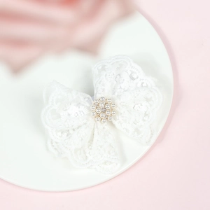 Gros plan sur un bandeau en dentelle blanche avec perle élégante et strass au centre
