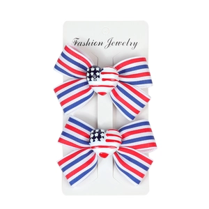 Detail of star and stripes themed bow hair clips with heart resin on a display card