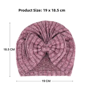 Détail du bonnet turban pour bébé en tricot côtelé rose foncé avec un grand nœud décoratif