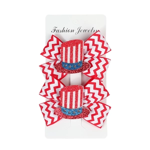 Detail view of 4th of July bow hair clips with patriotic patterns and glitter hats on card