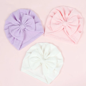 Three soft stretchy baby bow beanies in lavender, pink, and cream white set