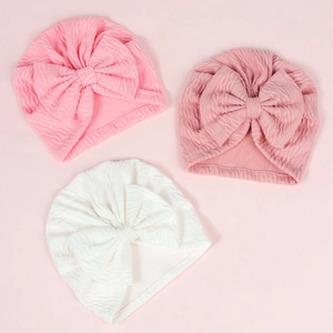 Set of three textured baby turban hats with large bows in pink and white seersucker fabric