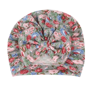 Close-up of baby turban beanie with colorful floral print and large bow knot detail