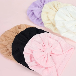 Set of six waffle knit baby hats with large bows in pink, black, purple, and beige