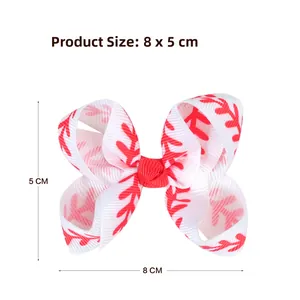 Close-up of a 3-inch white grosgrain hair bow with red leaf patterns and a metal clip