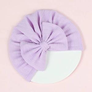 Close-up of purple ribbed knit baby turban featuring a large decorative bow
