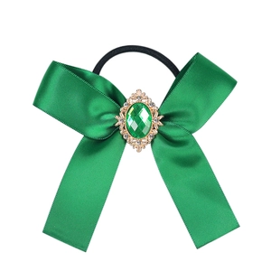 Details des dunkelgrünen Satin-Haargummis mit Vintage-Smaragd und goldener Verzierung